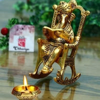 Golden Lord Ganesha Statue Sitting On A Rocking Chair And Reading Ramayan Showpiece